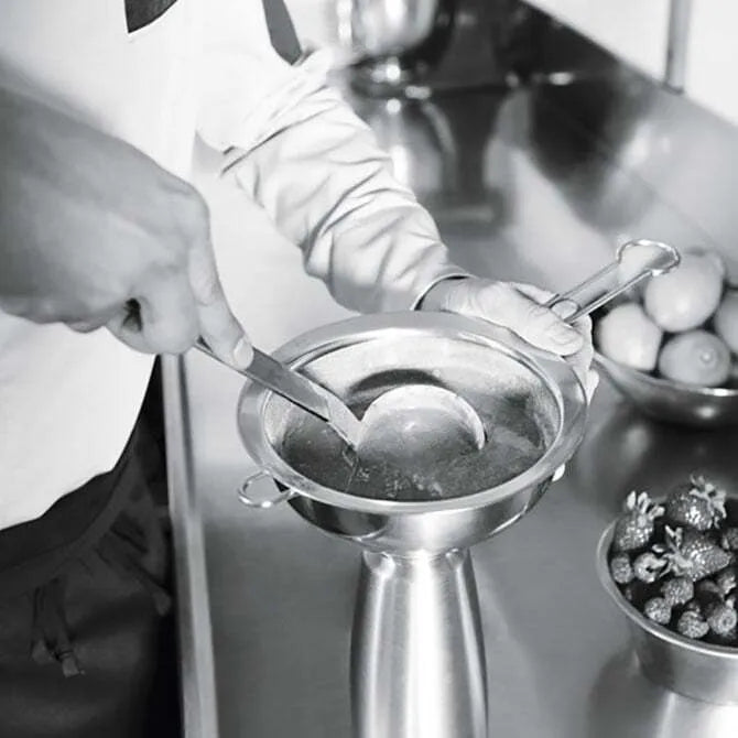 Black and white photo of chef using Funnel & Sieve from iSi