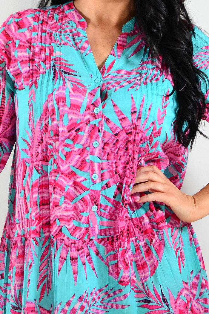 Aqua pink Beth tunic dress by One Summer displayed on a hanger, showcasing its flowing fabric and casual style.