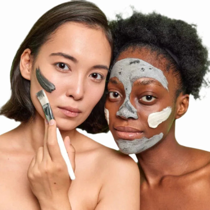 asian woman black woman applying sulphur  acne  facial mask with white brush dermal essentials clinical skincare