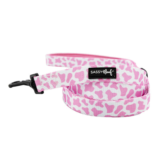 The Dog Leash - Strawberry Milk by Sassy Woof features a pink and white bone pattern, black clasp, and SASSY WOOF label—ideal to pair with pink dog accessories. It is shown coiled on a white background.