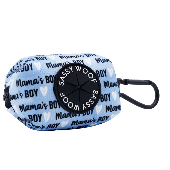 The Sassy Woof Dog Waste Bag Holder - Mama's Boy features a blue design with white hearts, "Mamas BOY" in dark blue, a black clip, and a round black Sassy Woof label.