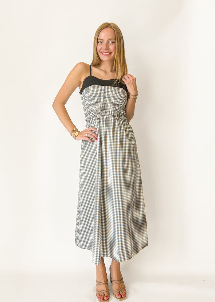 Woman wearing a checkered dress against a white background