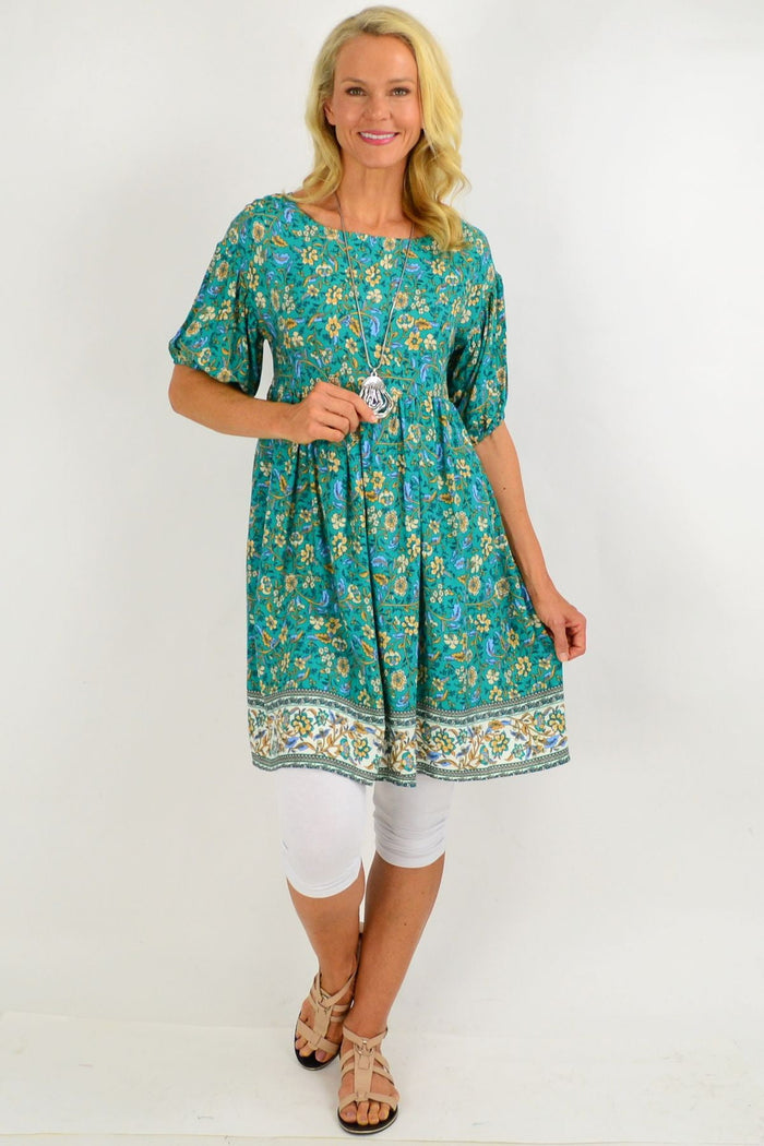 Emerald green puff sleeve tunic dress by Indigo Designs with floral pattern, displayed on a model.