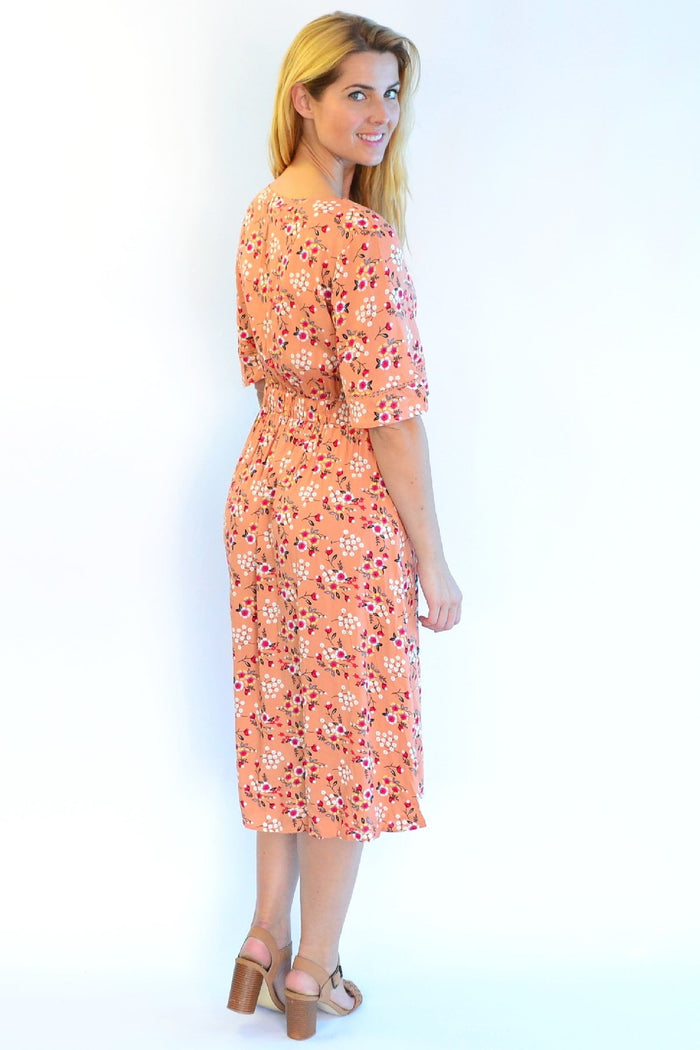 Dull orange Zen Garden Field of Flowers tunic dress with floral print and relaxed fit, displayed on a hanger.