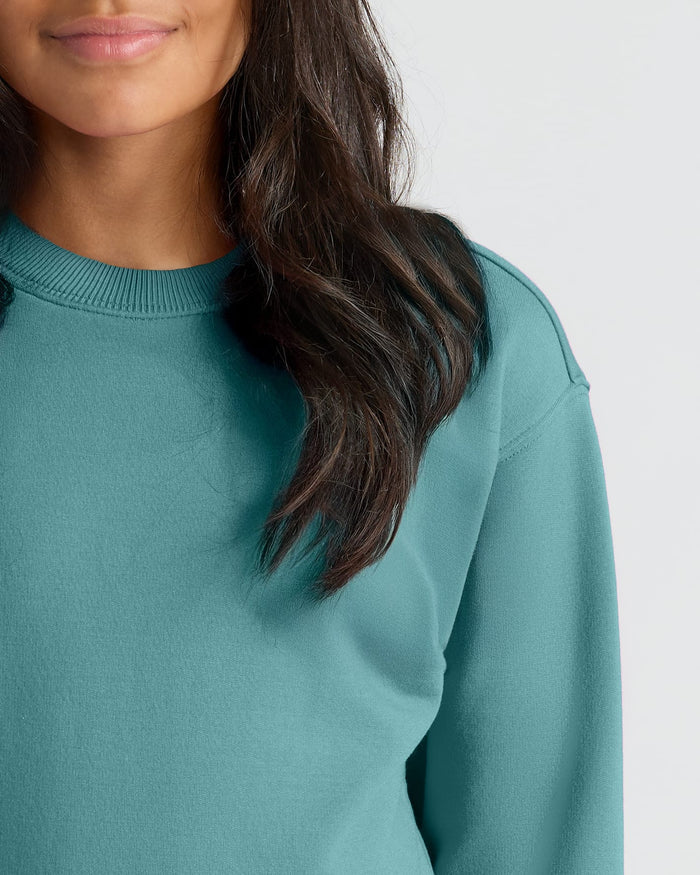 Girls Stormcloud Slouch Pullover Crew in teal on model's upper torso.