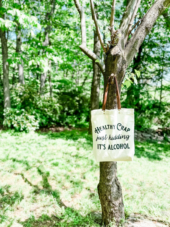 Tote bag that reads Healthy Crap, just kidding, it's alcohol hanging on a...
