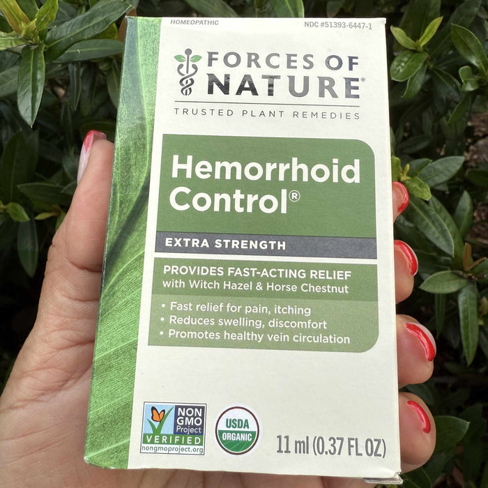 Front view of Hemorrhoid Control 11 ml box showing Provides fast-acting relief headline held in hand against leaves