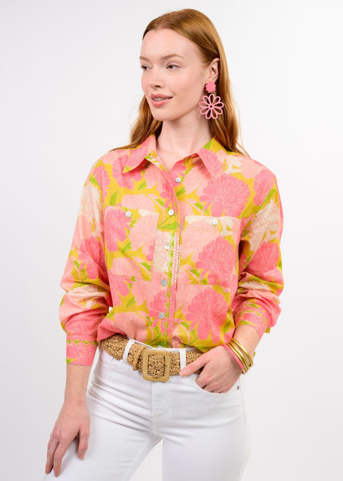 Woman wearing a pink floral button down with white jeans