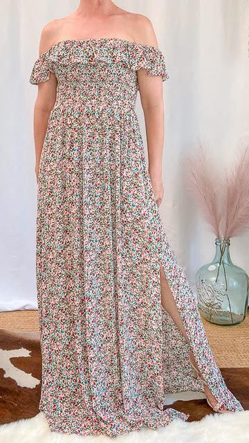 Woman wearing floral off-shoulder maxi dress with side slit in upscale women's boutique setting