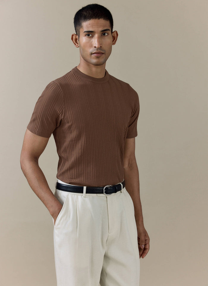 Percival Leon Slim Ribbed T Shirt in espresso brown organic cotton, styled on a model with cream tailored trousers.