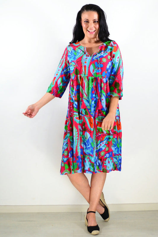 Colorful Natasha tie neck tunic dress by One Summer, featuring vibrant patterns and a relaxed fit, displayed on a hanger.