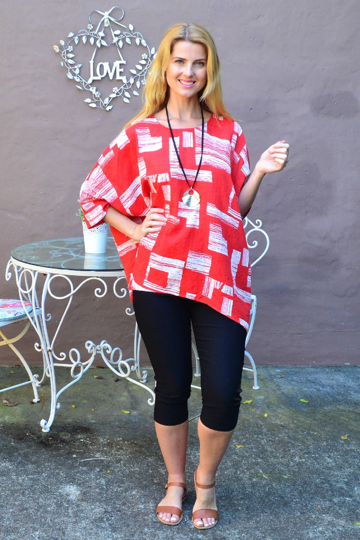 Orange-red and white block tunic top by Missy Q, featuring a stylish, relaxed fit with bold color blocking and long sleeves.