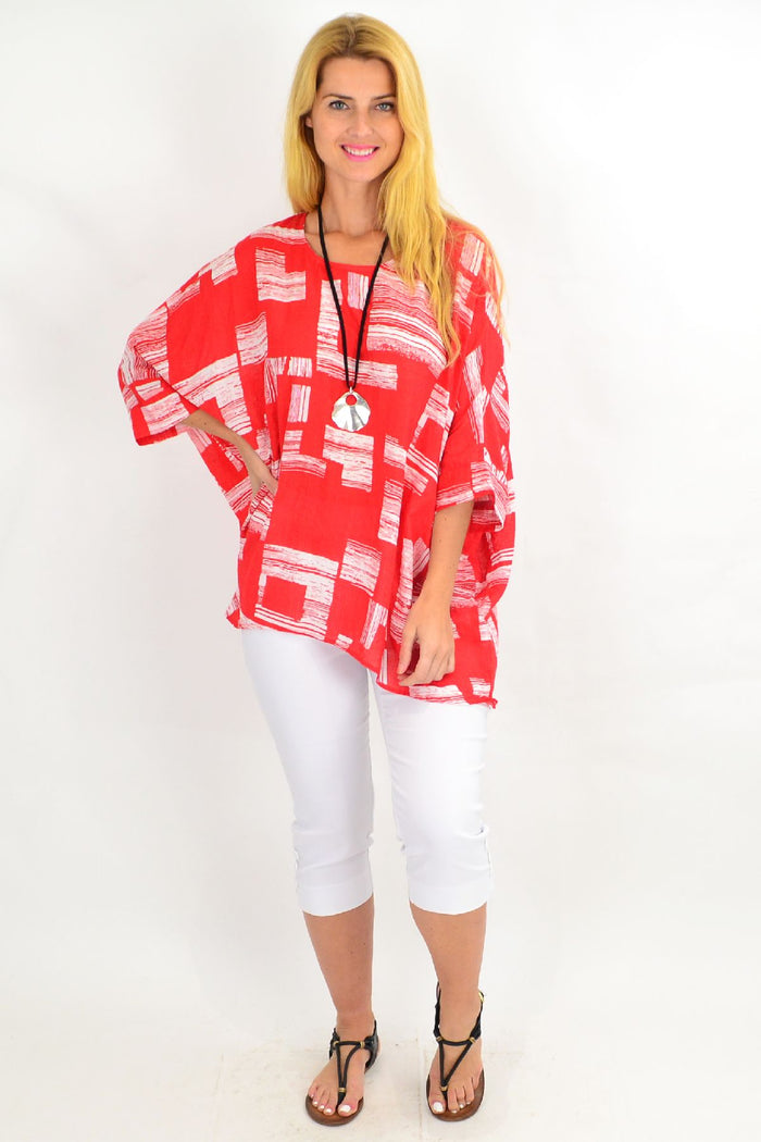 Orange-red and white block tunic top by Missy Q, featuring a relaxed fit and stylish design, shown on a hanger.