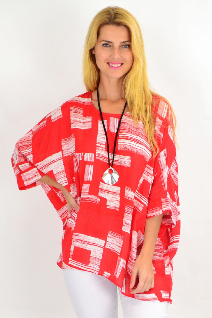 Orange-red and white block tunic top by Missy Q with long sleeves and a relaxed fit, displayed on a hanger.