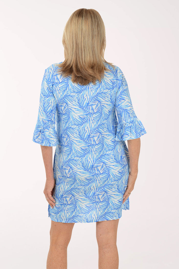 Woman wearing a blue leaf-patterned dress on a white background