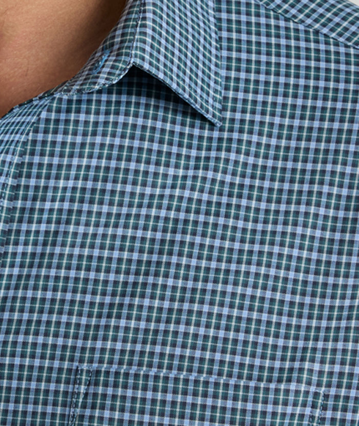 Model is wearing UNTUCKit Delune performance shirt in green check.
