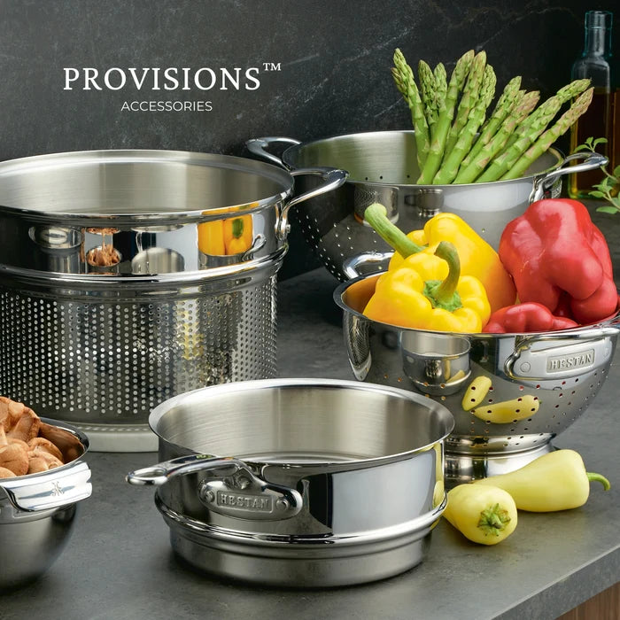 Stainless steel cookware set with vegetables on a dark surface, featuring the 'Provisions' brand.