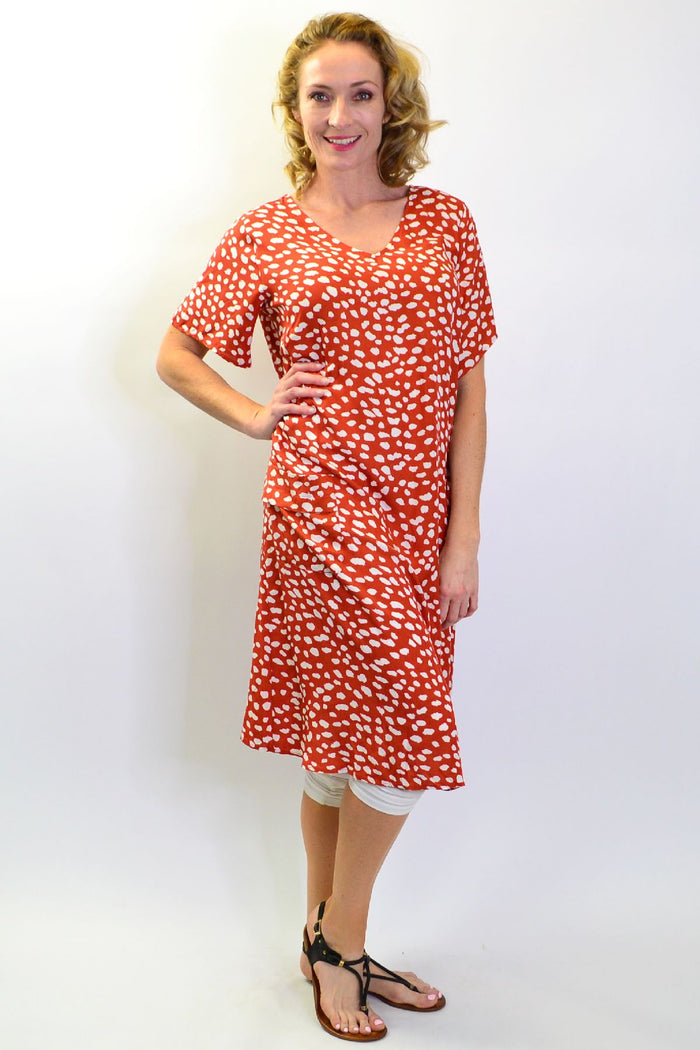 Sunshine Rust Dots and Pockets Tunic Slip Dress hanging on a mannequin with a relaxed fit and bohemian style.