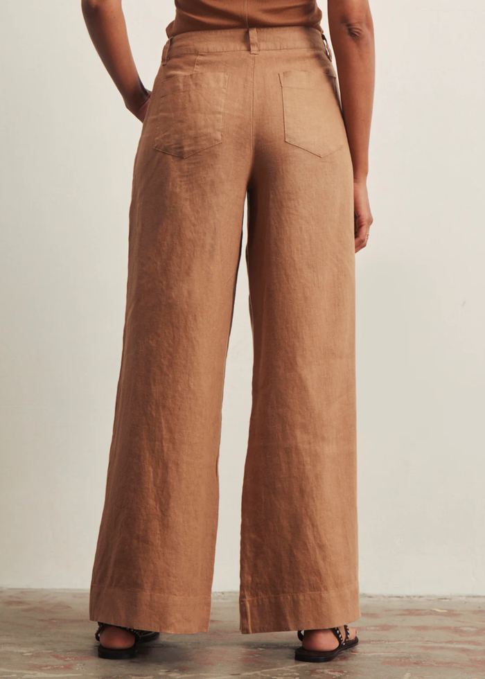 Woman turned around wearing brown wide leg pants with a brown tank top