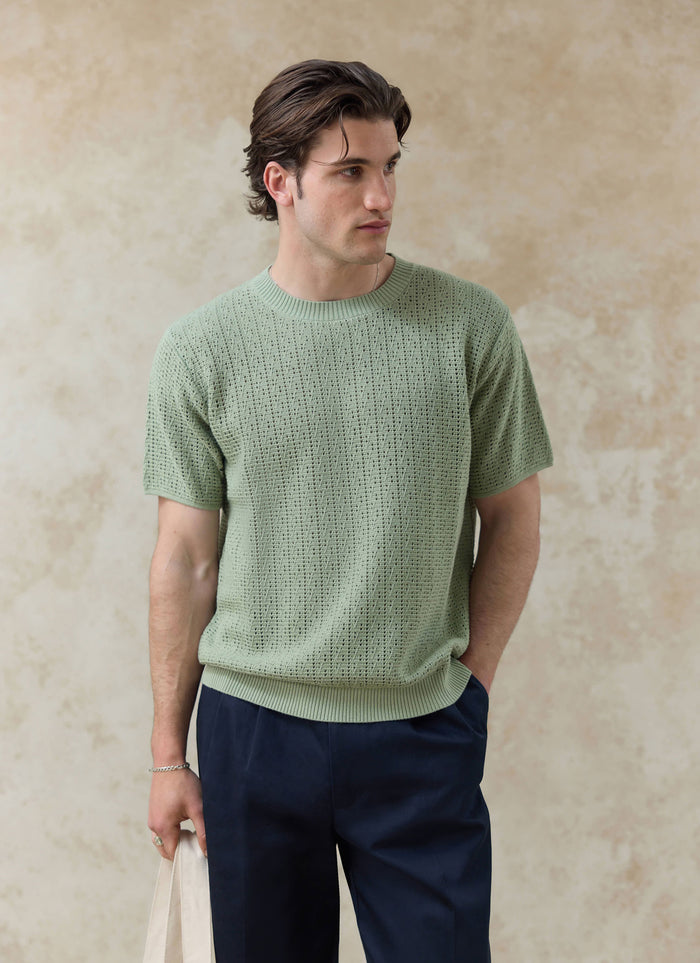 The Percival Siena Knitted T-shirt in pistachio, a pointelle cotton knit with ribbed trims, shown on a model.