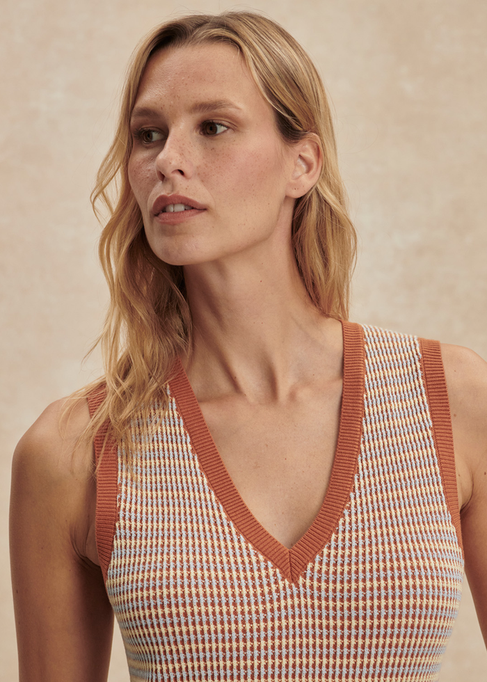 Close up of a woman woman wearing a multicolor knit dress with brown sandals