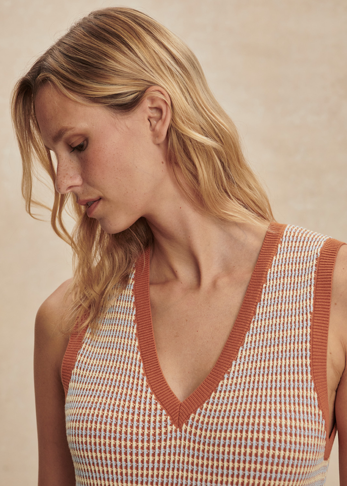 Close up of a woman woman wearing a multicolor knit dress with brown sandals