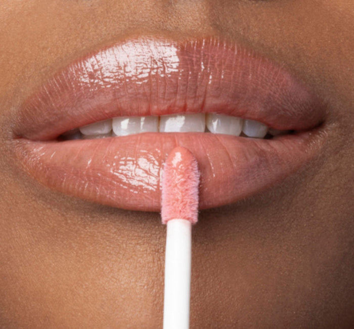 Close-up of lips applying Vitamin Glaze® Oil Infused Lip Gloss – Peach Peony | Farmhouse Fresh, showing glossy, sheer peach-colored finish enhancing natural lip beauty.