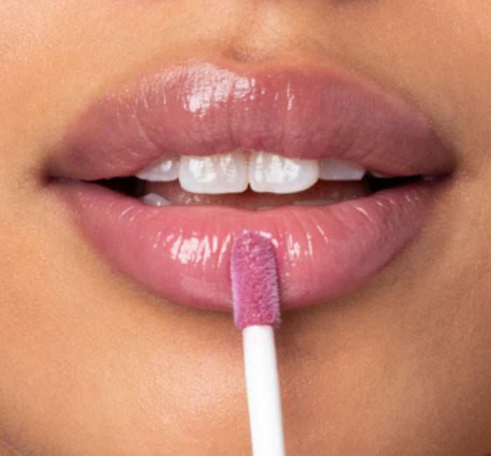 Close-up of lips being lightly glossed with Vitamin Glaze® Oil Infused Lip Gloss – Violet Orchid | Farmhouse Fresh, showing a sheer, violet orchid color and glossy finish.
