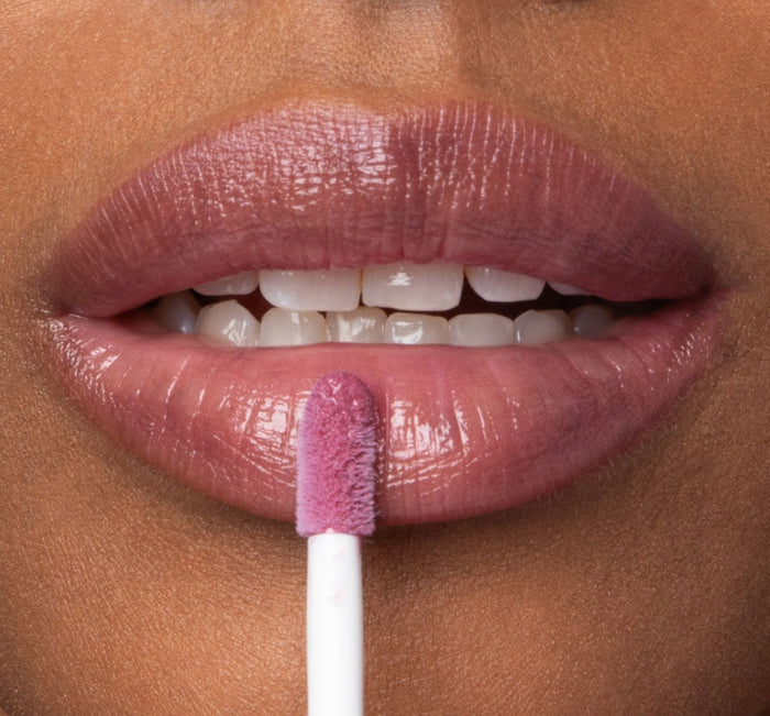 Close-up of lips applying Vitamin Glaze® Oil Infused Lip Gloss – Violet Orchid | Farmhouse Fresh, showcasing a sheer, glossy violet orchid tint for hydrated, radiant lips.