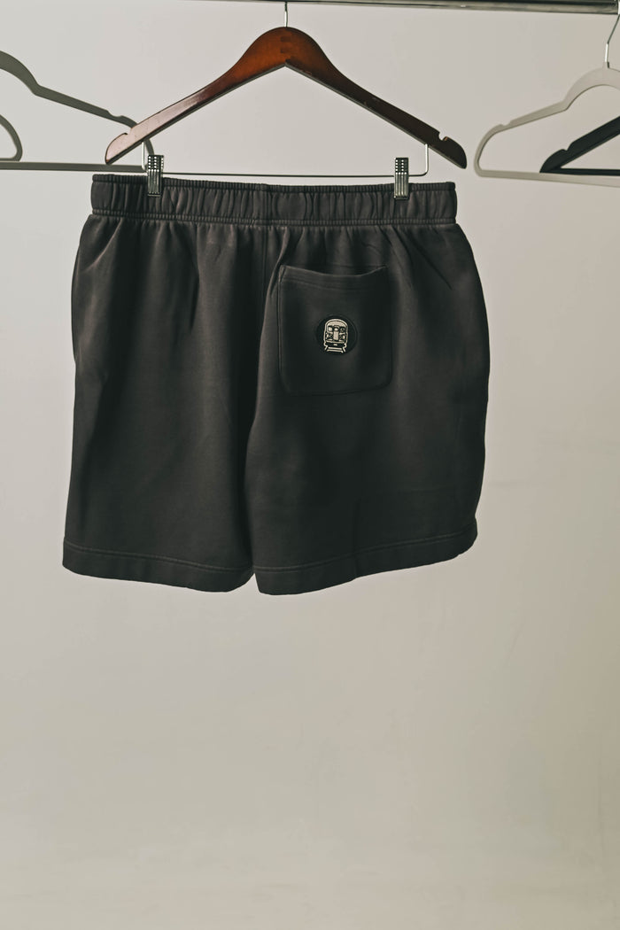 We Show Up Shorts with embroidered emblem on the back pocket.