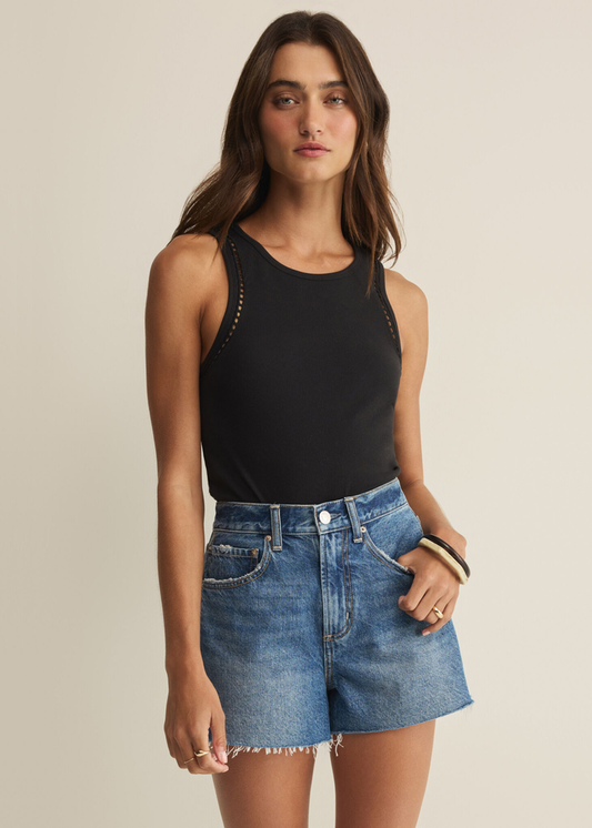 Woman wearing a black tank with denim shorts